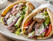Easy beef gyro recipe with seasoned beef, warm pita, fresh vegetables, and tzatziki sauce