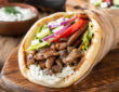 Easy pork gyro recipe with seasoned pork, warm pita, fresh vegetables, and tzatziki sauce