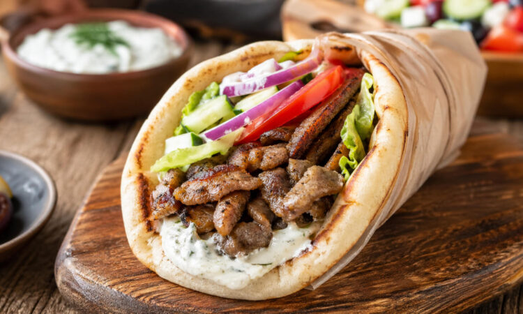 Easy pork gyro recipe with seasoned pork, warm pita, fresh vegetables, and tzatziki sauce