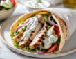 Healthy chicken gyro recipe with grilled chicken, warm pita, fresh vegetables, and Greek yogurt tzatziki sauce
