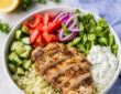 Easy low carb gyro bowl with keto gyro meat, cauliflower rice, cucumber, tomatoes, lettuce, and tzatziki sauce