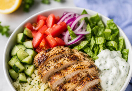 Easy low carb gyro bowl with keto gyro meat, cauliflower rice, cucumber, tomatoes, lettuce, and tzatziki sauce