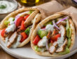 Easy oven baked chicken gyros with warm pita, Greek chicken, fresh vegetables, and tzatziki sauce