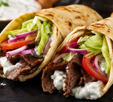 American gyro recipe with beef and lamb gyro meat, warm pita, lettuce, tomato, onion, and creamy gyro sauce