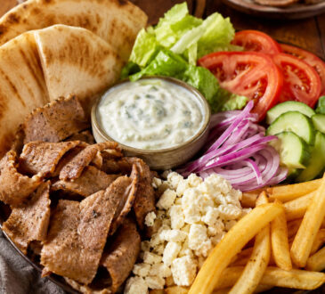 Gyro toppings with pita bread, sliced gyro meat, lettuce, tomato, cucumber, red onion, feta, fries, and tzatziki sauce