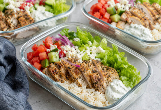 Chicken gyro meal prep bowls with Greek chicken, rice, cucumber, tomatoes, red onion, lettuce, and tzatziki sauce
