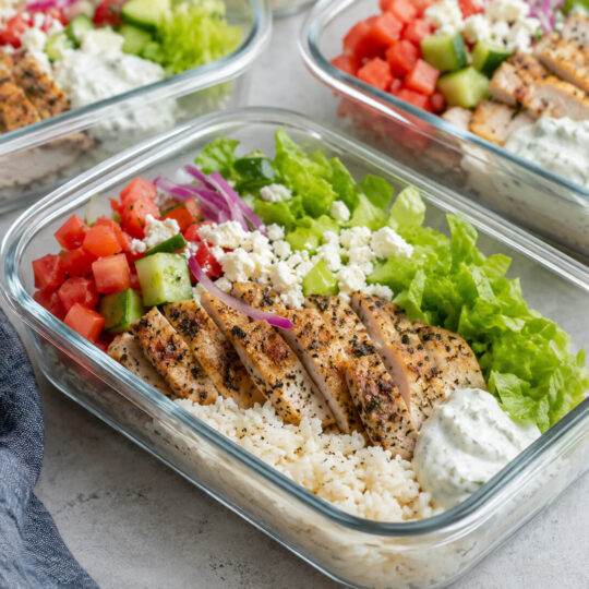 Chicken gyro meal prep bowls with Greek chicken, rice, cucumber, tomatoes, red onion, lettuce, and tzatziki sauce