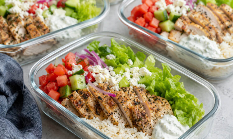 Chicken gyro meal prep bowls with Greek chicken, rice, cucumber, tomatoes, red onion, lettuce, and tzatziki sauce